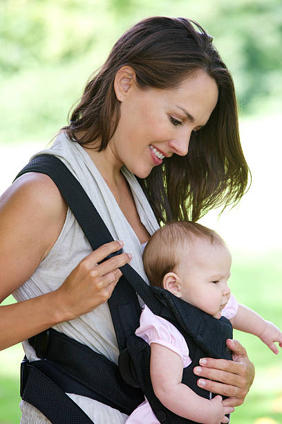 istock Mother smiling with baby in sling 517058725