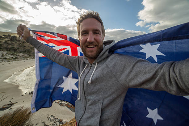 istock Young man on beach holding Australian's flag 517059112