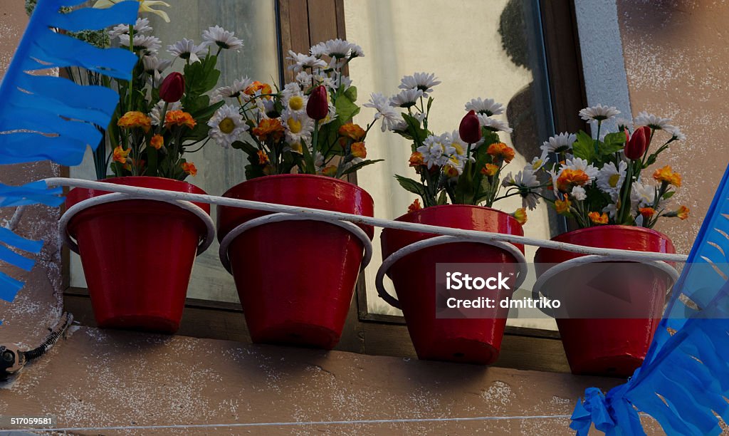 Colorful flowerpots hanging from a window in Tossa de Mar Architecture Stock Photo