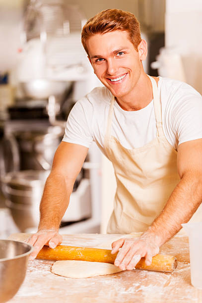 Man rolling out the dough.
