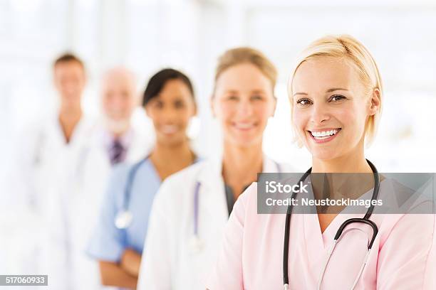 Smiling Female Nurse With Medical Team Stock Photo - Download Image Now - Nurse, 20-24 Years, 20-29 Years