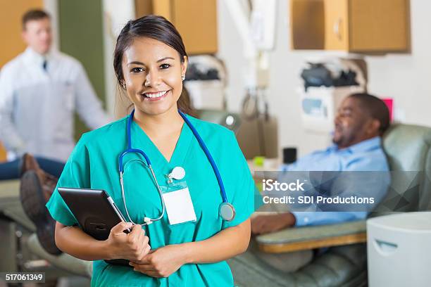 Friendly Young Nurse Smiling In Busy Blood Donation Center Stock Photo - Download Image Now
