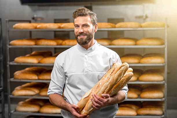 istock Baker holding baguettes at the manufacturing 517074448