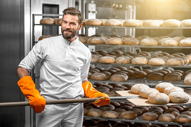 istock Baker putting with shovel bread loafs at the manufacturing 517074786