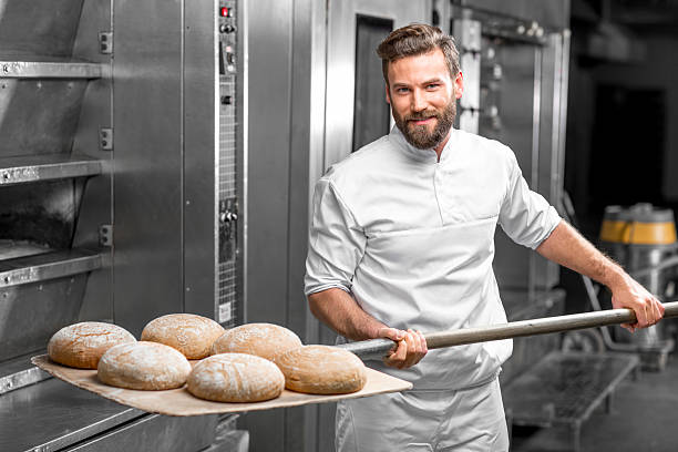 istock Baker taking out from the oven baked buckweat bread 517075504