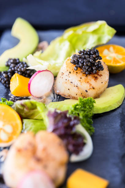 istock Pan seared scallops with salad, avocado, radish, mango and black 517077466