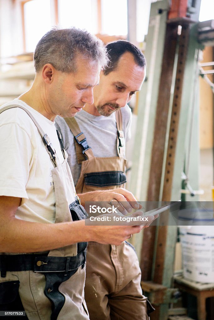 modern Craftsman working with a touchpad for planing carpenter using touchpad for work Adult Stock Photo