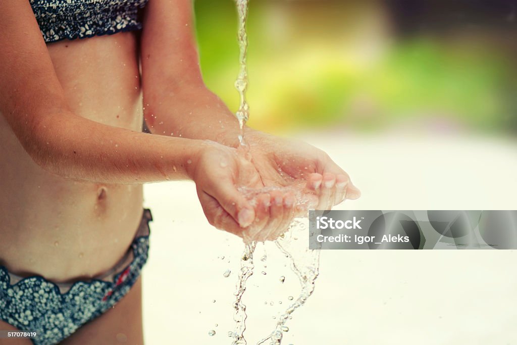 Stream of clean water pouring into children's hands. Catching Stock Photo