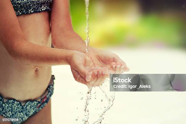 Stream Of Clean Water Pouring Into Childrens Hands Stock Photo - Download Image Now