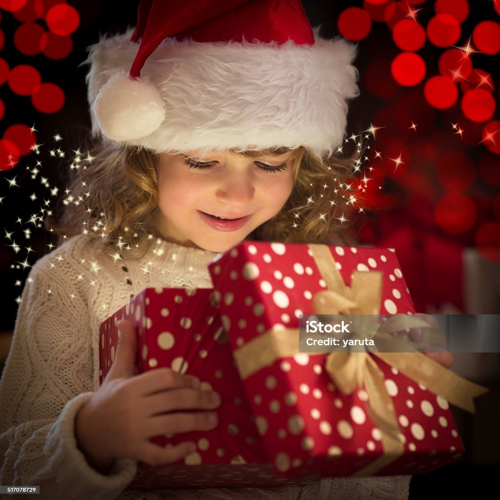 Christmas gift Happy child in Santa hat opening Christmas gift box Child Stock Photo