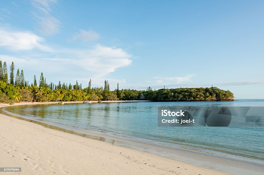 Kanumera bay on the Isle of Pines in New Caledonia Kanumera bay on the Isle of Pines in New Caledonia. There are pleasure boats in the bay which is surrounded by pacific cedars and is known as one of the most beautiful bays in the world. Bay of Water Stock Photo