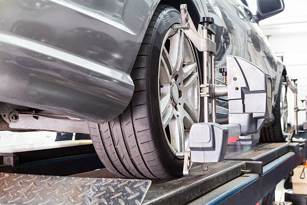 istock Closeup of tire clamped with aligner undergoing auto wheel align 517080356