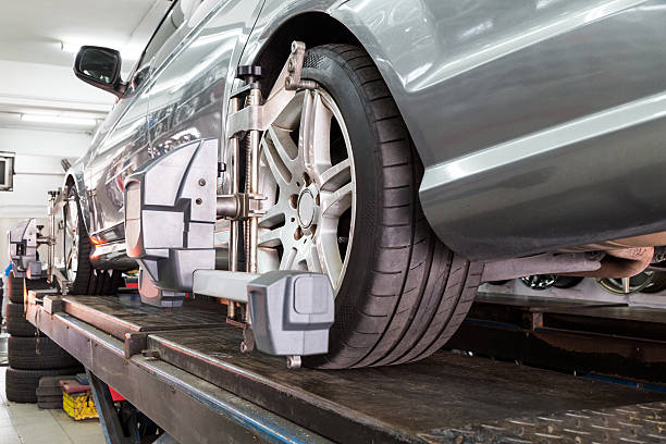 istock Closeup of tire clamped with aligner undergoing auto wheel align 517080628