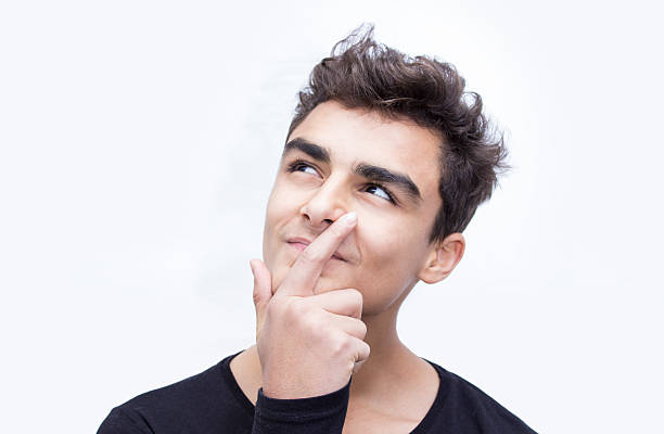 Front view portrait of smiling child thinking over white background. Young man wearing casual clothes. Thinking boy standing in front of isolated on white and looking away with positive facial expression. Horizontal compositon. Teenage boy's ethnicity belongs to Turkish, middle eastern ethnicity.