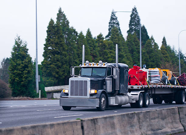 istock Classic black semi truck big rig flat bed commercial load 517088706