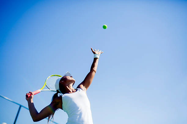 Beautiful female tennis player serving Beautiful female tennis player serving outdoor racket sport stock pictures, royalty-free photos & images