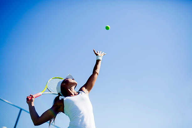 beautiful female tennis player serving - 封閉式球場 圖片 個照片及圖片檔