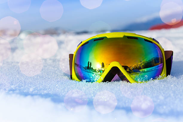 View of yellow ski mask on white icy snow View of yellow ski mask on white icy snow with reflection of mountains face guard sport photos stock pictures, royalty-free photos & images