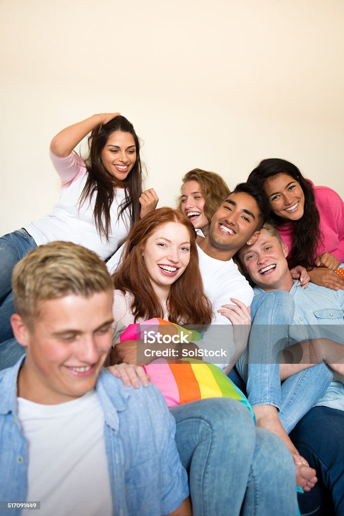Group Of Students In Accommodation Group of young adults in student accommodation sitting together Friendship Stock Photo