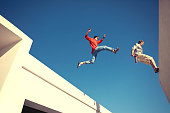 two brave men jumping over the roof