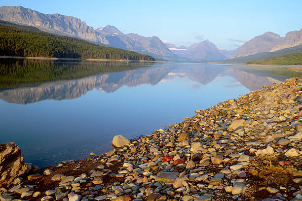 istock Water reflections along a clear lake in Glacier National Park. 517095611