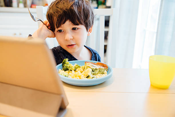 Eating and Watching a Tablet Computer stock photo
