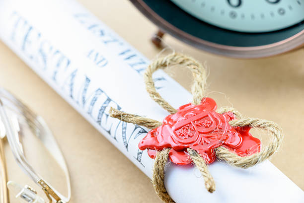 Rolled up scroll of last will and testament. Rolled up scroll of last will and testament fastened with natural brown jute twine hemp rope, sealed with sealing wax and stamped with alphabet letter B. Decorated with an antique clock and glasses. probate photos stock pictures, royalty-free photos & images