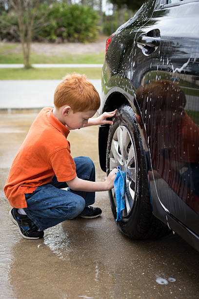 istock Little boy helping wash his father's car 517106530