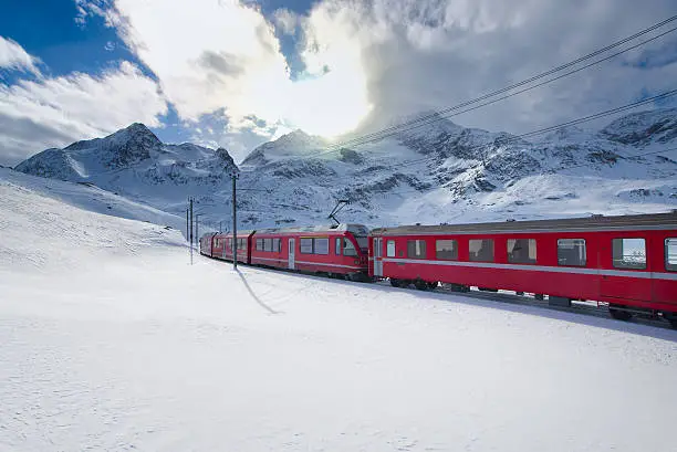 Swiss mountain train Bernina Express crossed through the high mountain snow