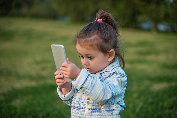 istock Cute toddler girl using smart phone 517107250