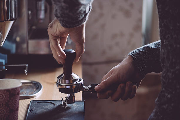 istock Man tamping fresh morning coffee 517109478