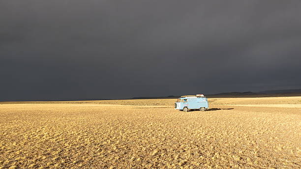 Cardiel, Santa Cruz, Argentina - Febuary 11, 2016: A blue VW Bus from 1973 in the light of the setting sun while a thunderstorm is building up over the pampa of Argentina.