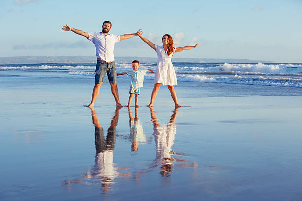 istock Happy family walking with fun on sunset sea beach 517110564
