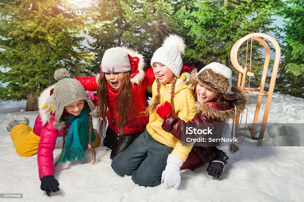 Amigos jugando juntos en juegos de invierno en la nieve - Foto de stock de Abrazar libre de derechos