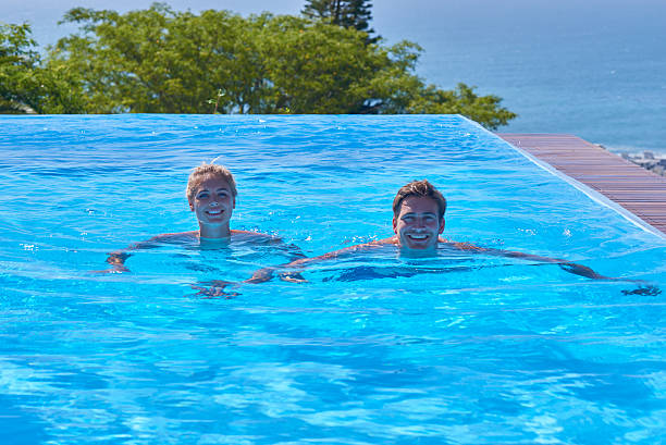 istock Attractive young couple relaxing in awesome pool 517122432