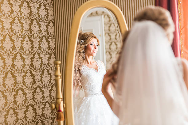 istock young bride looks at herself in the mirror 517122922