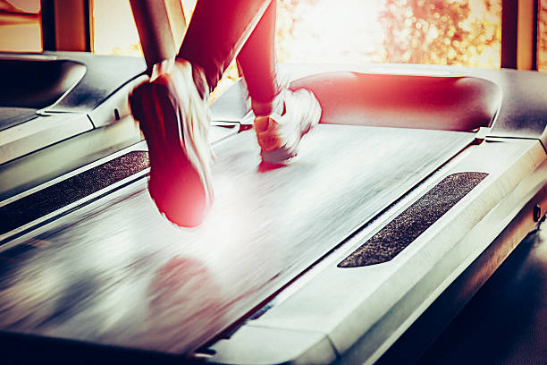 Woman running on treadmill in health club.