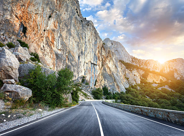 istock Beautiful mountain asphalt road with rocks, blue sky at sunset 517125736