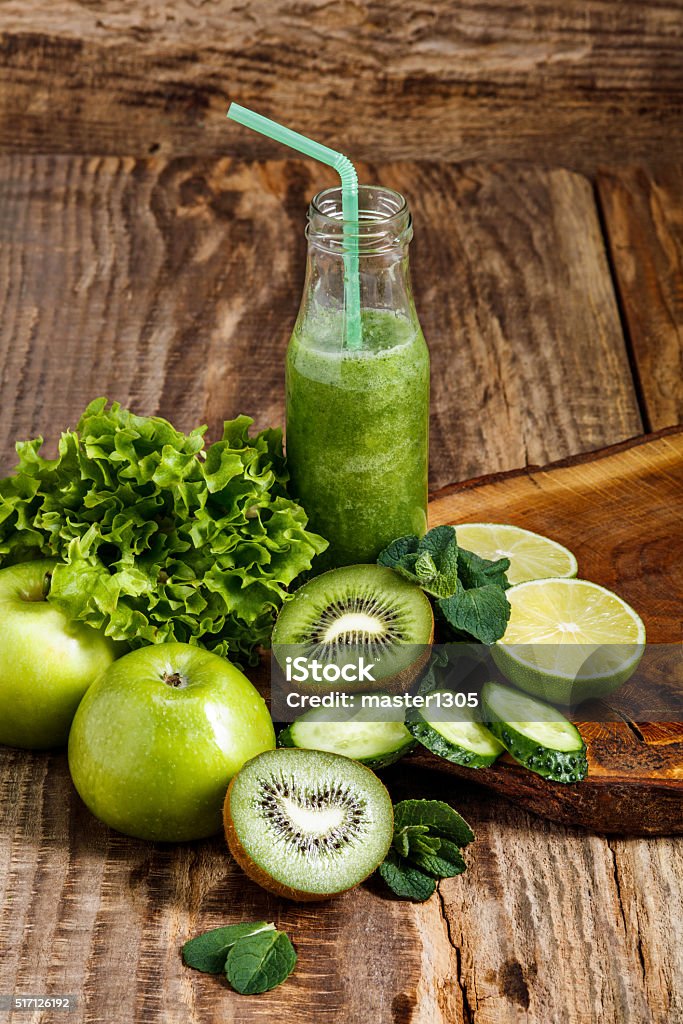 The bottles with fresh vegetable juices on wooden table The bottles with fresh vegetable and kiwi fruit juices on wooden table. Detox diet. Antioxidant Stock Photo