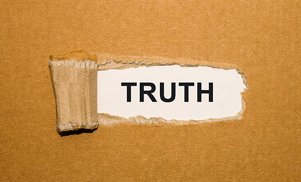 The text Truth appearing behind torn brown paper