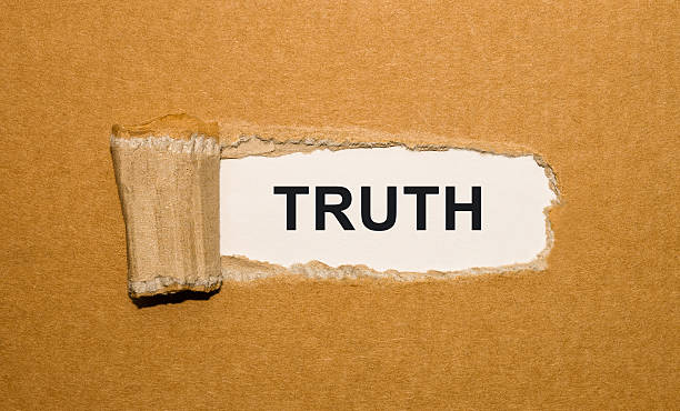 The text Truth appearing behind torn brown paper stock photo