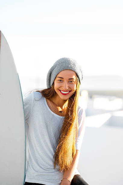 mujer con tabla de surf en el blanco fondo de la ciudad - high key portrait color image travel locations fotografías e imágenes de stock