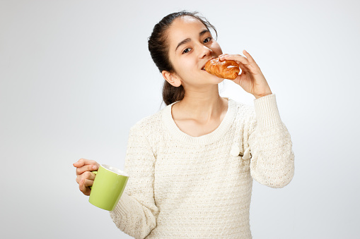 Young girl eating croissant