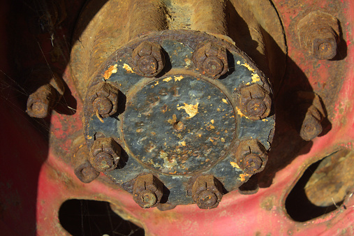 Very rusty lugnuts are holding this wheel on this forgotten truck.