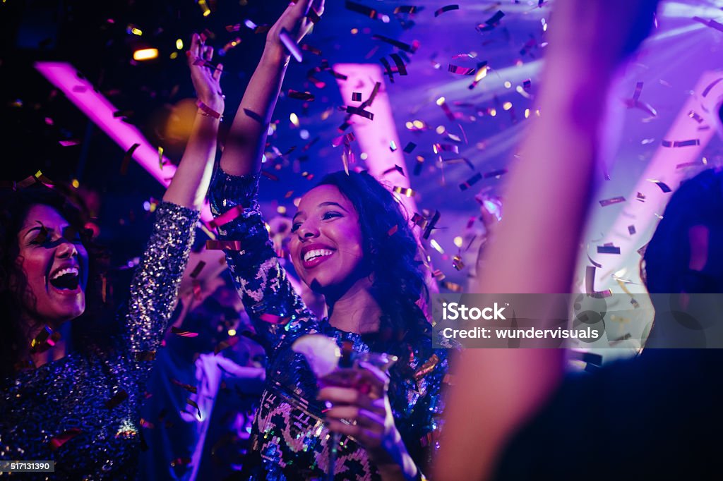 Happy young friends partying with drinks and confetti in nightclub - Royaltyfri Fest Bildbanksbilder