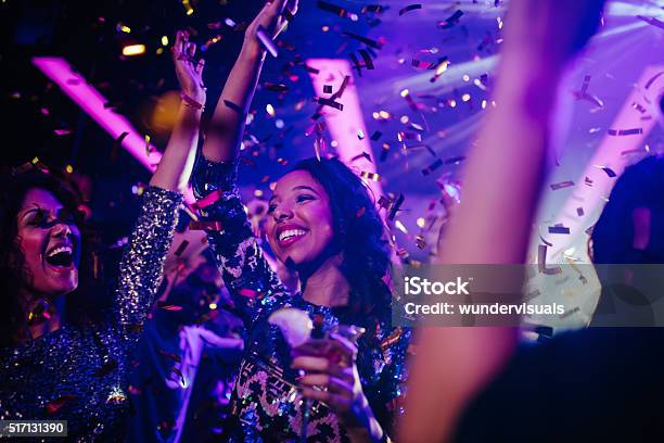 Happy Young Friends Partying With Drinks And Confetti In Nightclub-foton och fler bilder på Fest