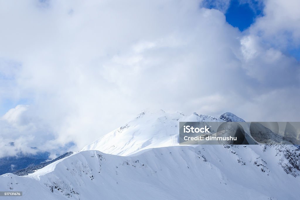 Building on top snowy mountain ridge in sunlight and clouds Small chalet building on the top of snowy mountain ridge in the sunlight and clouds in Rosa Ski Resort Krasnaya Polyana Sochi Russia Beauty In Nature Stock Photo