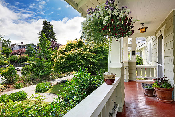 istock Entrance porch with flower pots overlooking front yard 517132391
