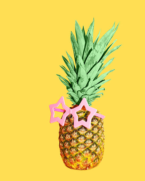 istock Pineapple with pink sunglasses on yellow background, colorful an 517133202