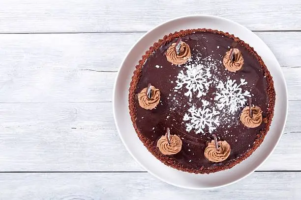 chocolate cake decorated with chocolate chips and icing-sugar snowflake, close-up